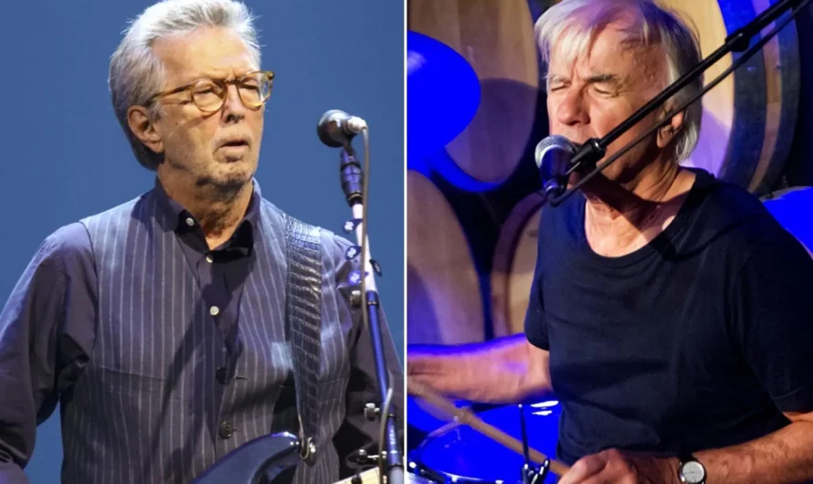 Yardbirds drummer Jim McCarty recently shared insights into Eric Clapton’s early career and the deliberate approach that helped shape his path to stardom. He spoke in an interview with Guitar Player.  McCarty reflected on Clapton’s difficult upbringing and how it influenced his dedication to music and his carefully crafted image.  “Eric was coming from a difficult upbringing, because he wasn’t really brought up by his parents. He was brought up by his grandmother, who he thought was his mother,” McCarty said. “We met her, and she was a lovely woman, very chatty and very friendly. But that gave him a challenged outlook on things, and I think he took the blues up as his personal crusade.”  The drummer noted Clapton’s strategic attention to fashion and appearance, which set him apart from the beginning.  “He was totally dedicated to the blues, and also seemingly very ambitious and very much into fashion and how he looked. He made sure he was dressed in the latest gear, and the coolest clothes,” McCarty recalled. “Even when he came to the audition, he was very well-dressed. And he would change. First of all, it was an Ivy League style, and he had a crew cut, and then he’d suddenly grow his hair and grow his sideburns and have different clothes and become like a different person.”  Despite his drive and talent, McCarty also remembered Clapton’s moodiness during their time together.  “Eric was obviously gonna go somewhere. You knew that, yes, one day he’ll be a big star, ’cause he was driven to do that, and he was getting a reputation while he was playing with us,” he said. “But he was a very moody sort of guy. We’d be traveling in a transit van, going to the shows, and he would sit in the corner and not talk to anybody. The rest of us would be messing about, and he’d be in a little world of his own, obviously quite unhappy with the way it was going.”  Clapton’s time with the Yardbirds proved to be a crucial stepping stone in his legendary career. It would ultimately end due to creative differences.  Where’s Eric reported that Clapton’s departure from the Yardbirds was influenced by the band’s shift towards a more commercial sound, particularly with their single “For Your Love.” This marked a turning point where Clapton sought more blues-oriented projects that aligned with his musical vision.  During his tenure with the band, Clapton developed the blues sound that would become his trademark. Eric Clapton’s official website noted that he was particularly drawn to the blues after hearing artists like Freddie King and B.B. King. Their influence shaped his musical direction and style throughout his career.  It was also during this period that Clapton earned his famous nickname “Slowhand.” Eric Clapton’s official website explained that the nickname originated from the audience’s practice of slow-hand clapping between songs as they waited for him to replace strings on his guitar, which would often break during performances.  The Yardbirds played a pivotal role in launching not only Clapton’s career but also those of Jeff Beck and Jimmy Page. Wikipedia documented that all three guitarists are now renowned for their contributions to rock music, cementing the band’s legacy as a launching pad for some of the genre’s most influential musicians.  The comments provide a rare glimpse into the early years of one of rock’s most influential guitarists and reveal the calculated strategy behind his rise to stardom.